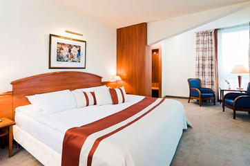 Гостиничный номер в Mercure Poznan Centrum в светлых тонах &mdash; двуспальная кровать, столик и два кресла