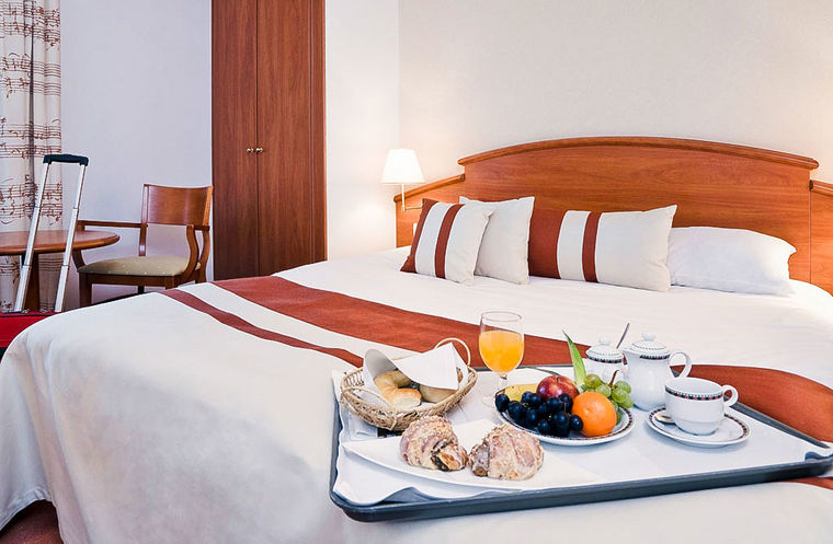 Гостиничный номер в Mercure Poznan Centrum &mdash; двуспальная кровать в минималистичном стиле, стоик и кресло