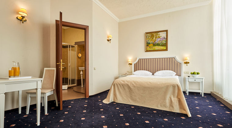 Гостиничный свадебный номер люкс City Holiday Resort & Spa &mdash; двуспальная кровать с высокой мягкой спинкой, прикроватные тумбочки, стул Орион