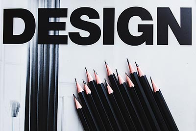 Заголовок DESIGN на фоне чёрных карандашей.
